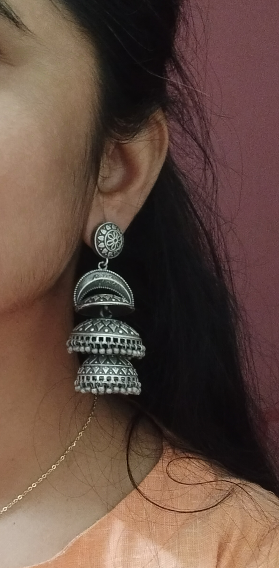 Close-up of a person wearing a silver and black earrings with a blurred background, silver earring, Jhumka